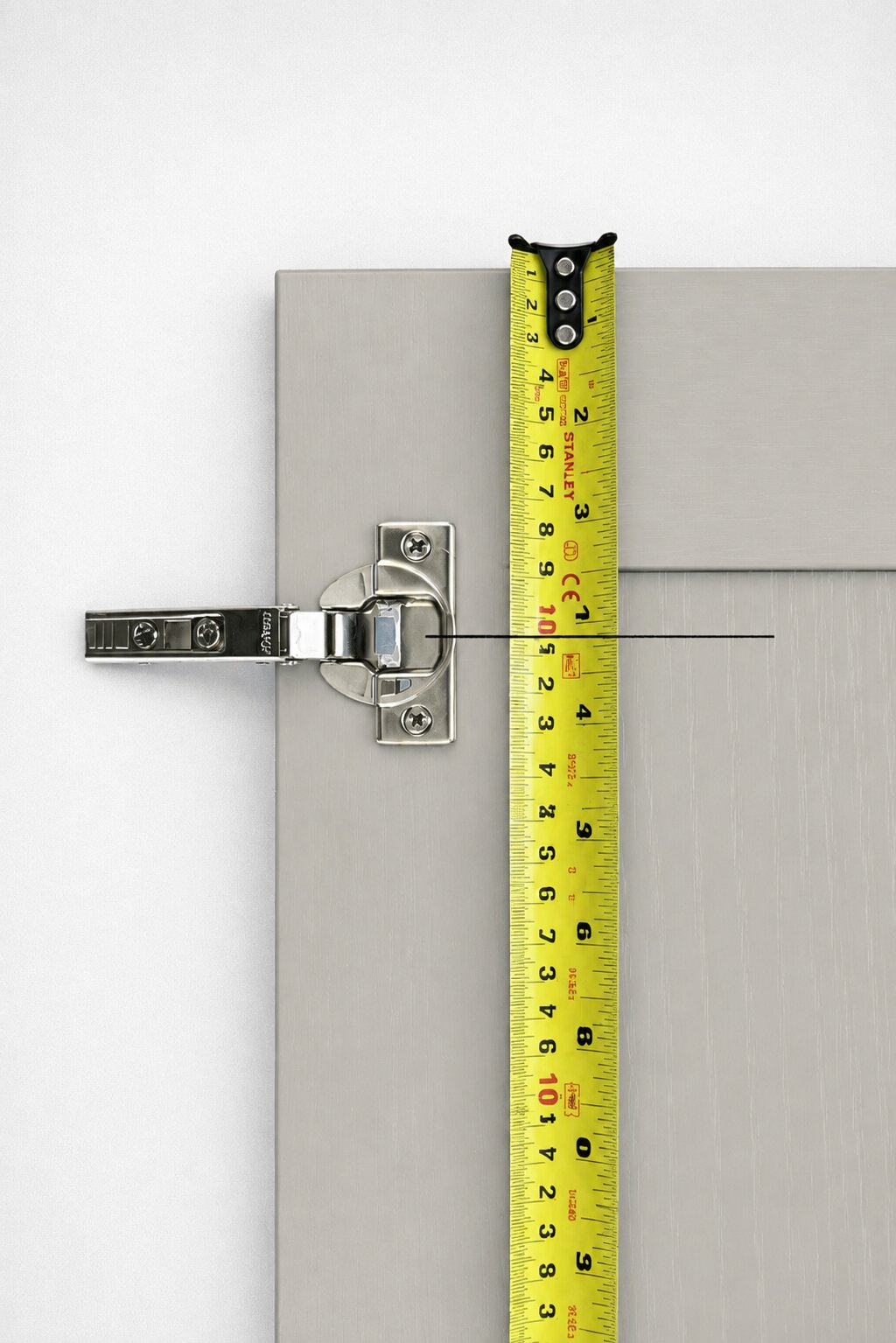 Measuring to a pencil line marking the centre of a kitchen door hinge hole